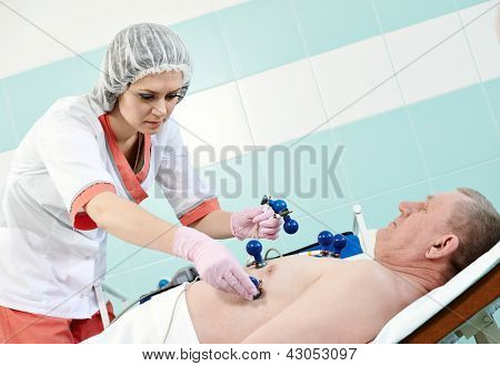 젊은 간호사 병원 클리닉에서 의료진 전기 cardiogramm 테스트에서 남성 환자와 의사
