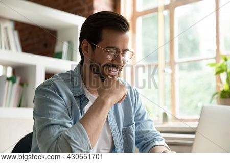 Smiling Handsome 35s Man Sit At Desk Working On Laptop
