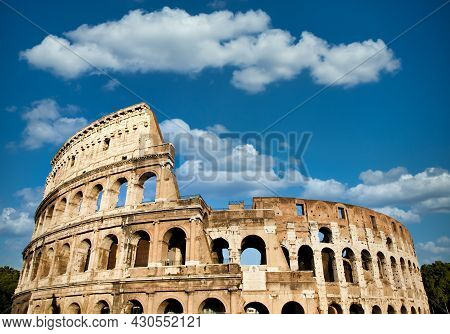 Rome, Italy. Arches Archictecture Of Colosseum (colosseo) Exterior With Blue Sky Background And Clou