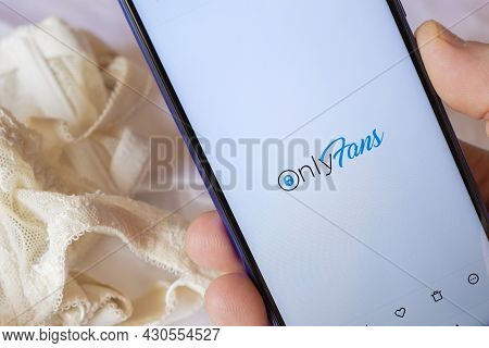 Carrara, Italy - August 22, 2021 - Smatphone With A Lace Bra On The Background, Shows The Onlyfans L