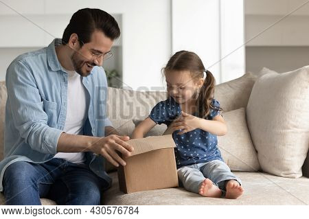 Happy Dad And Excited Daughter Girl Unboxing Parcel With Gift