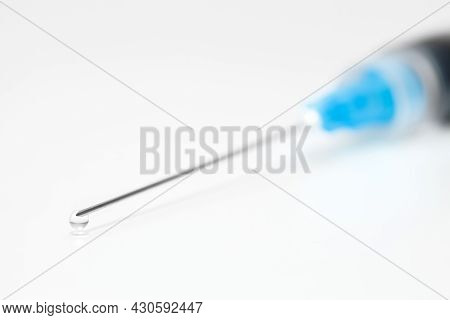 Needle сlose-up On Syringe And Drop Of Liquid Medicine At End.
