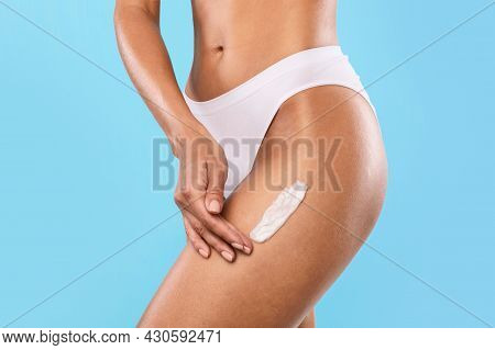 Closeup Of Young Woman Apply Lotion On Her Legs