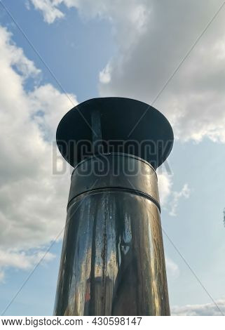 A Pipe With A Cover Made Of Galvanized Aluminum Iron On A Background Of Blue Sky And Clouds On A Sun