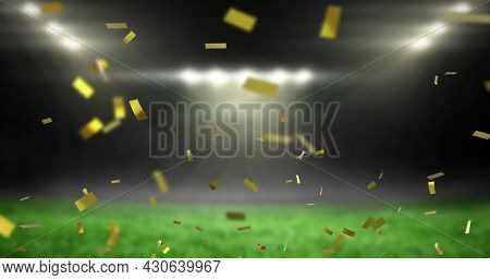Image of golden confetti falling over empty sports stadium. competition victory celebration concept digitally generated image.