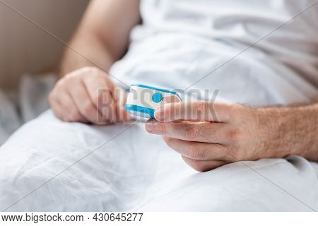 Health Care. Close Up Of Hands Of Hospitalized Patient, Lying At Bed And Holding A Pulse Oximeter. C