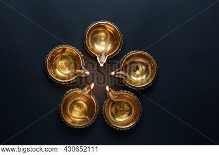 Lit Diyas On Dark Background, Flat Lay. Diwali Lamps