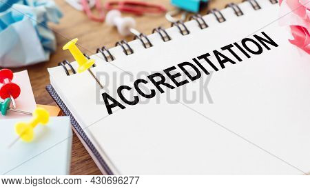 Accreditation - Text On A Notepad With Wrinkled Paper And Paper Needles On Wooden Background.
