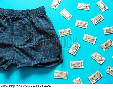 Condoms Package And Boxer Shorts On Blue Background. Safe Sex And Reproductive Health Concept. Condo