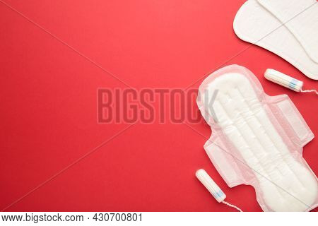 Menstrual Tampons And Pads On A Red Background. Menstruation Cycle. Hygiene And Protection. Top View