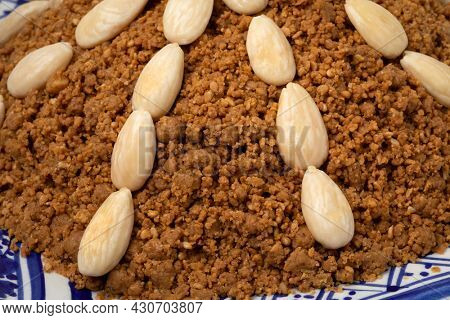 Traditional Moroccan homemade sellou decorated with roasted almonds close up