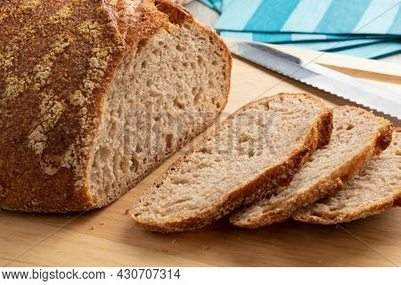 Sliced whole fresh baked German dinkel wheat bread on a cutting board close up