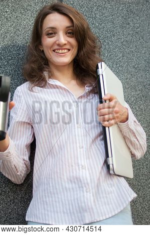 Female Portrait Of Young Woman With Silver Laptop And Cup Of Coffee Waiting For A Meeting Near Dark 