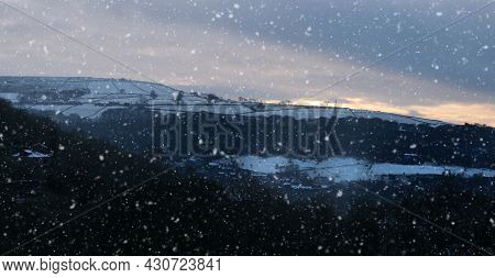 Panoramic View Of A Glowing Orange Sunset In A Cloudy Twilight Winter Sky With Falling Snow In Calde