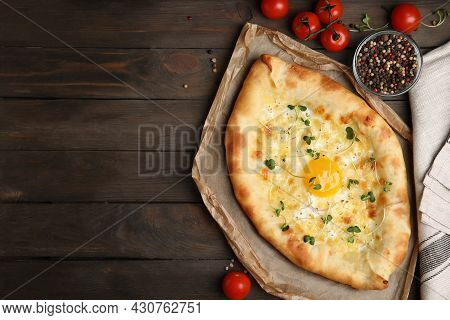 Fresh Delicious Adjarian Khachapuri Served On Wooden Table, Flat Lay. Space For Text
