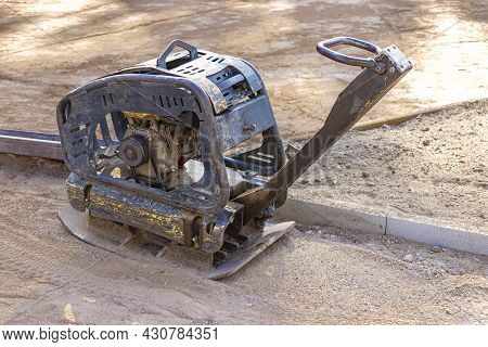 Vibratory Rammer With Vibrating Plate On A Construction Site. Compaction Of The Soil Before Laying P