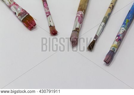 Dirty Art Paint Brusches Of Different Sizes And Colors On White Background, Copy Space