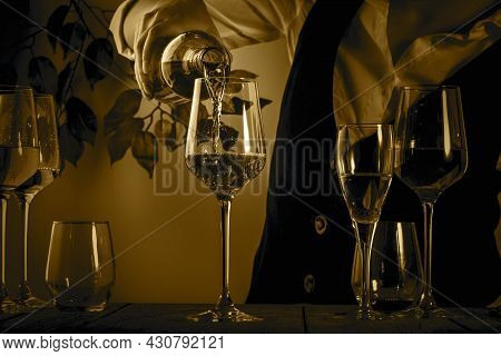 Sommelier Pouring Rose Wine Into Glass At Wine Tasting In Winery, Bar Or Restaurant. Toned Image