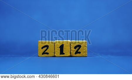 The Wooden Block Shows The Number 212. Isolated On Blue Background