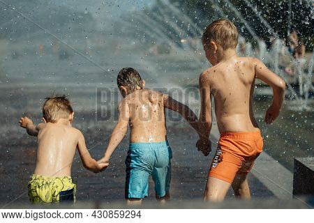 Three Caucasian Boys Going To Run Throgh Splashing Fountain On Hot Summer Day In City Of Saint-peter