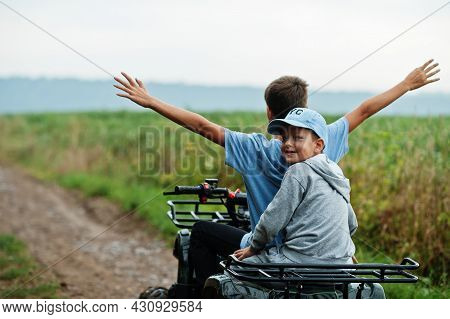 Two Brothers Driving Four-wheller Atv Quad Bike. Happy Children Moments.