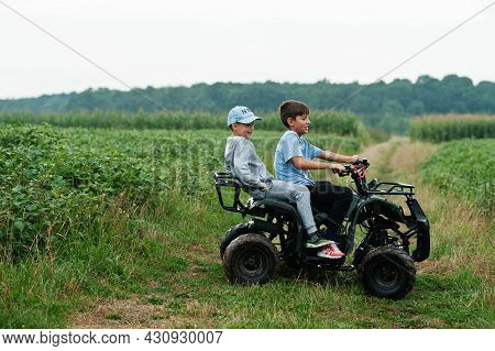 Two Brothers Driving Four-wheller Atv Quad Bike. Happy Children Moments.