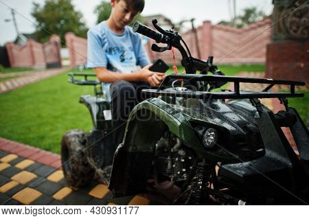 Boy In Four-wheller Atv Quad Bike With Mobile Phone.