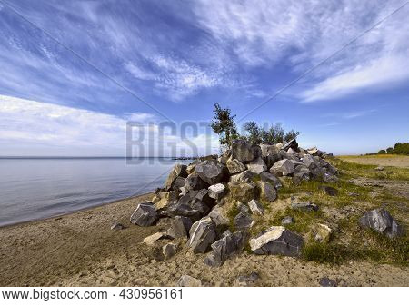 Stone Hill On The Bank Of The River. A Pile Of Stones On The Sandy Shore Of The Novosibirsk Reservoi