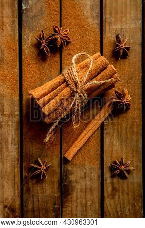 CINNAMON STICKS ON WOODEN BACKGROUND