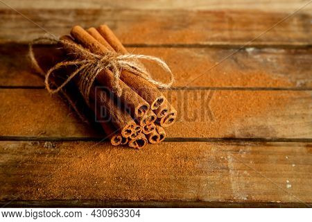 CINNAMON STICKS ON WOODEN BACKGROUND