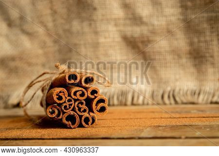 CINNAMON STICKS ON WOODEN BACKGROUND