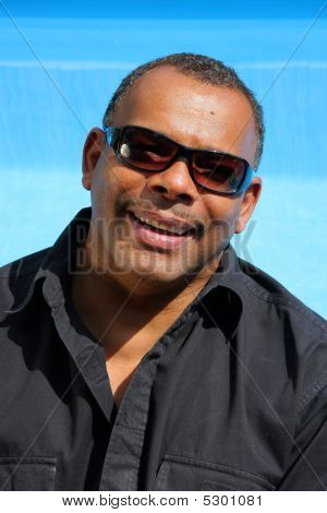A Successful And Happy African American Man Sitiing At His Pool