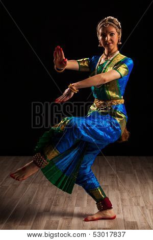 Young beautiful woman dancer exponent of Indian classical dance Bharatanatyam in Shiva pose