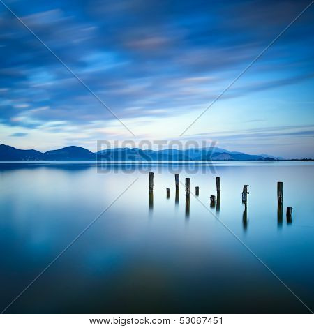 Wooden Pier Or Jetty Remains On A Blue Lake Sunset And Sky Reflection On Water. Versilia Tuscany, It