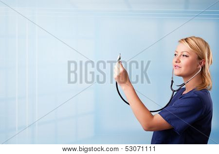 Pretty young nurse in hospital listening to empty copy space with sthetoscope