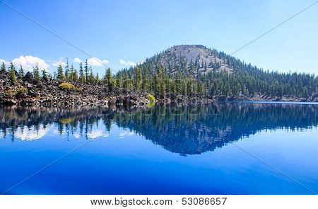 Clear reflection of Wizard Island in the Sapphire Blue Waters of Crater Lake, Oregon