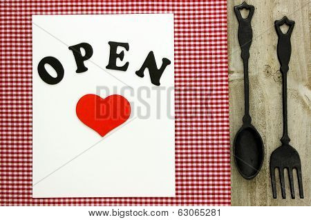 Open sign with cast iron spoon and fork