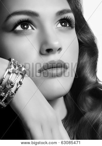 Beautiful woman with golden jewelry on dark background