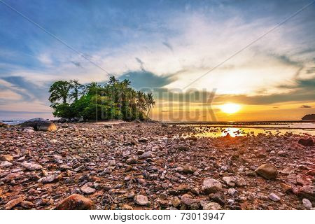 Tropical beach in ebb time on sunset background