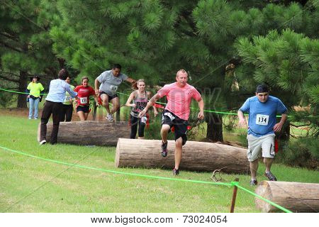 MUSKOGEE, OK - Sept. 13: Athletes jump over obstacles during the Castle Zombie Run at the Castle of Muskogee in Muskogee, OK on September 13, 2014. 