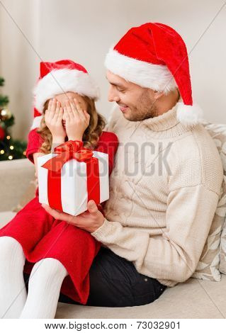 family, christmas, x-mas, winter, happiness and people concept - smiling daughter with closed eyes waiting for a present from fathe