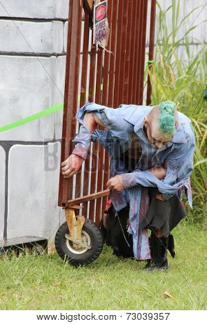 MUSKOGEE, OK - Sept. 13: A bloody zombie holds a metal fence, ready to chase his victims during the Castle Zombie Run at the Castle of Muskogee in Muskogee, OK on September 13, 2014. 