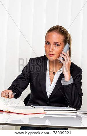 business woman sitting in an office. symbol photo for managers, independence or lawyer.