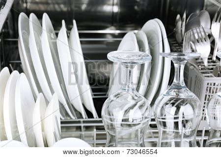 Open dishwasher with clean utensils in it
