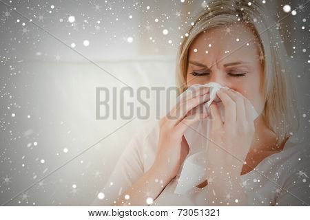 Composite image of ill woman blowing her nose against snow