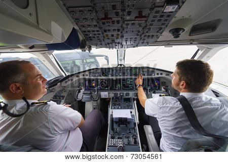 GENEVA - SEPTEMBER 11: Etihad Regional pilots in aircraft cockpit on September 11, 2014 in Geneva, Switzerland. Darwin Airline, operating under the brand name Etihad Regional since January 2014