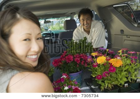 Paar laden bloemen in achterkant van Suv, portret
