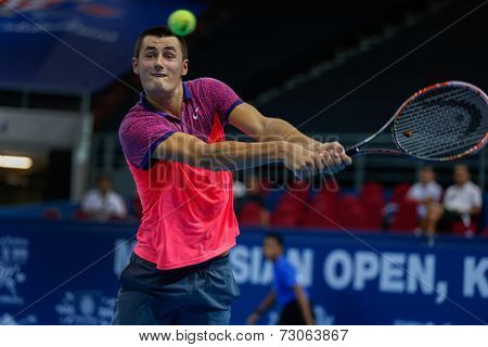 SEPTEMBER 23, 2014 - KUALA LUMPUR, MALAYSIA: Bernard Tomic of Australia makes a backhand return in his first round match at the Malaysian Open Tennis 2014 event. This is an ATP sanctioned tournament.