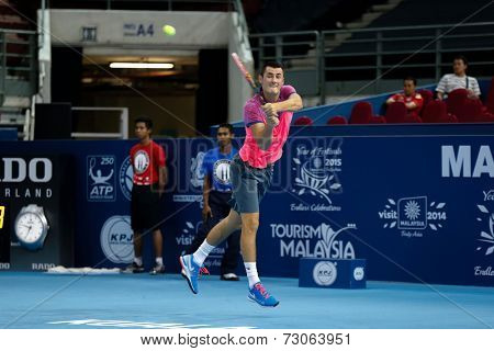 SEPTEMBER 23, 2014 - KUALA LUMPUR, MALAYSIA: Bernard Tomic of Australia makes a backhand return in his first round match at the Malaysian Open Tennis 2014 event. This is an ATP sanctioned tournament.