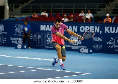 SEPTEMBER 23, 2014 - KUALA LUMPUR, MALAYSIA: Bernard Tomic of Australia makes a backhand return in his first round match at the Malaysian Open Tennis 2014 event. This is an ATP sanctioned tournament.